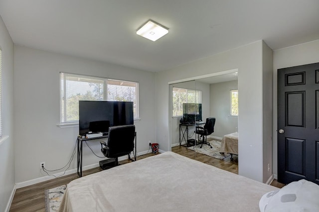 bedroom with a closet, wood finished floors, and baseboards