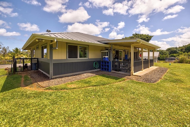 exterior space with fence, metal roof, a patio, and a yard