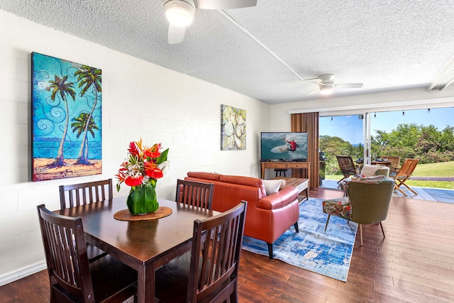 dining area with a textured ceiling, dark wood-type flooring, and ceiling fan