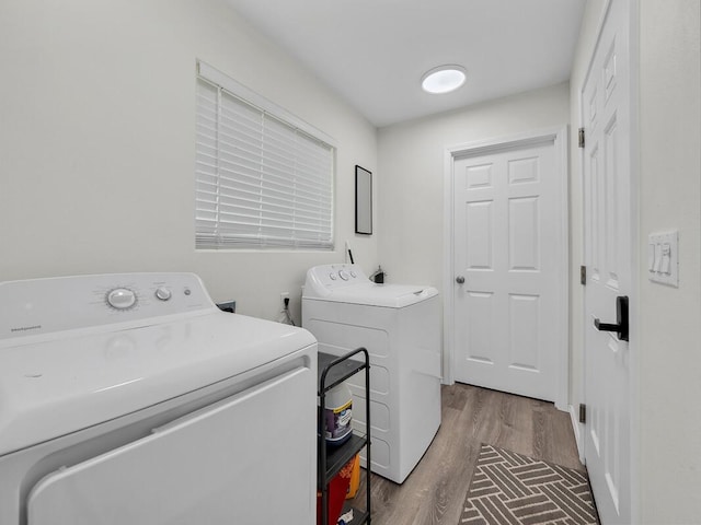 clothes washing area with washer and clothes dryer and hardwood / wood-style floors