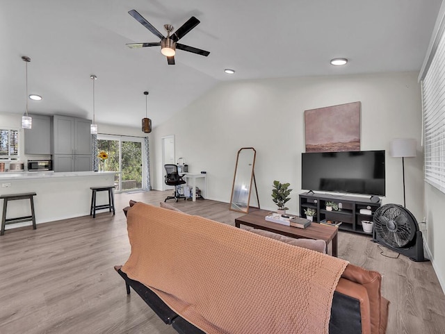 living room featuring vaulted ceiling, ceiling fan, and light hardwood / wood-style flooring