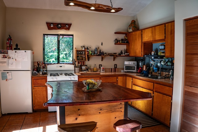 kitchen featuring light tile patterned flooring, sink, and white fridge