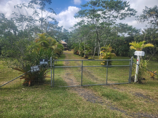 view of gate with a yard