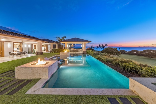 pool at dusk featuring a gazebo, a patio, and an outdoor fire pit