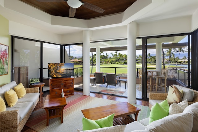 sunroom / solarium featuring ceiling fan, wood ceiling, and a tray ceiling