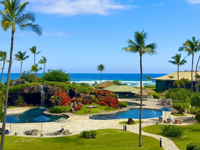 view of swimming pool with a lawn and a water view