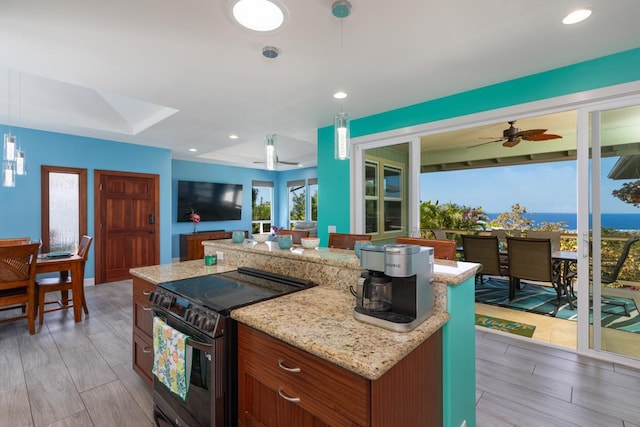 kitchen featuring light stone counters, recessed lighting, range with electric cooktop, open floor plan, and pendant lighting