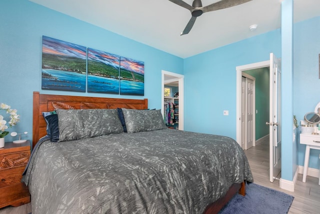 bedroom with wood finished floors, a ceiling fan, and baseboards