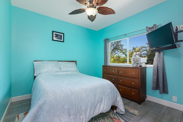 bedroom featuring ceiling fan, wood finished floors, and baseboards