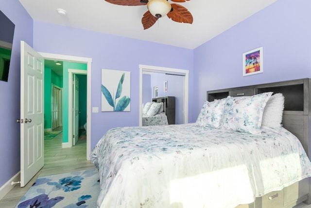 bedroom featuring baseboards, ceiling fan, a closet, and light wood-style floors