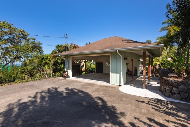 view of property exterior with roof with shingles and an outdoor structure