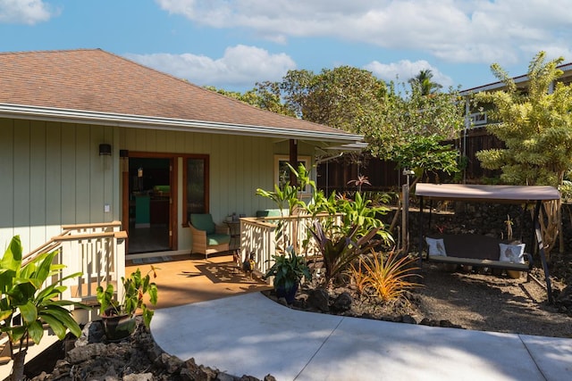 exterior space featuring a shingled roof, fence, and a patio