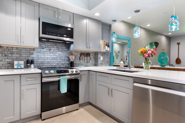 kitchen with gray cabinetry, sink, hanging light fixtures, and appliances with stainless steel finishes