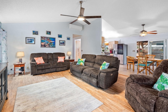 living room with lofted ceiling, an AC wall unit, light wood-type flooring, and a ceiling fan