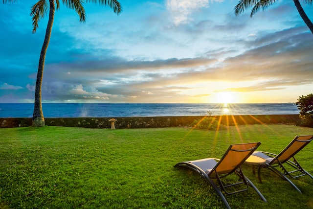 yard at dusk featuring a water view