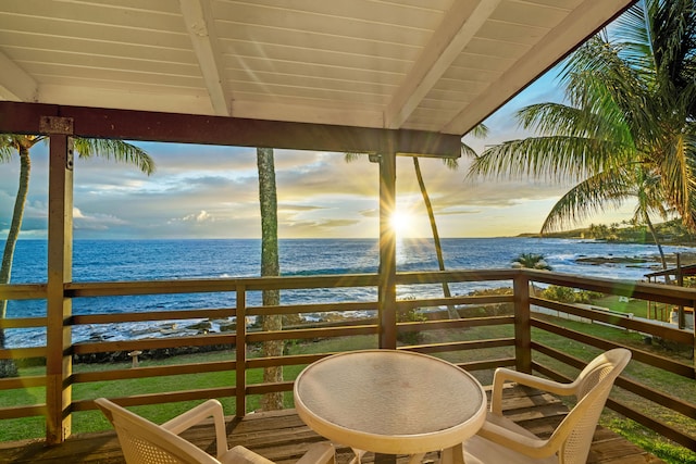 balcony at dusk with a water view and a beach view