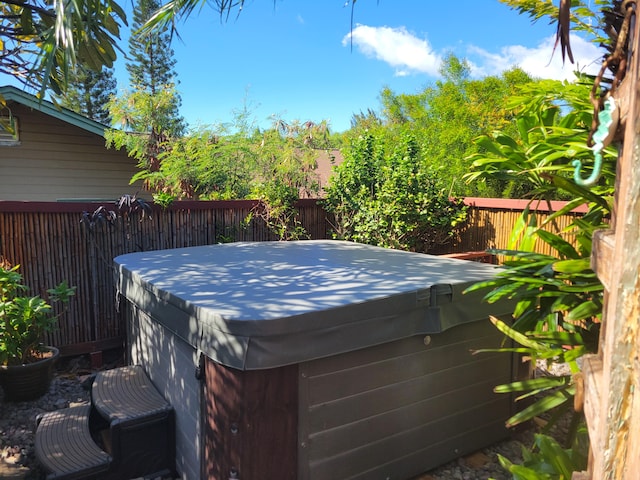 exterior space featuring a hot tub and fence