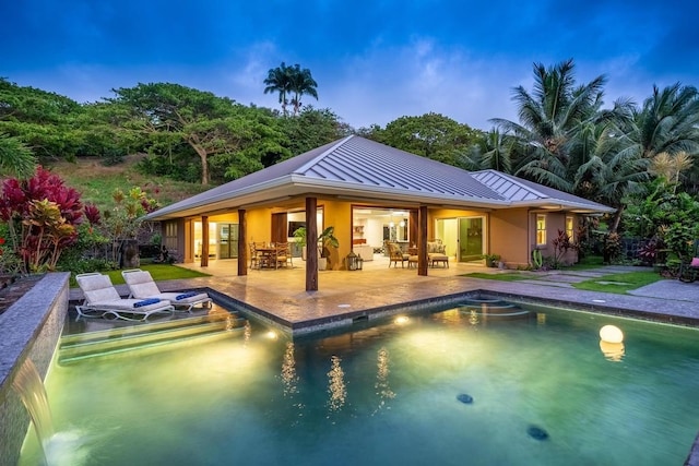 pool at dusk featuring a patio area