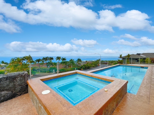 view of swimming pool featuring a water view and an in ground hot tub