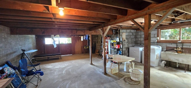 basement featuring washer and clothes dryer and a sink