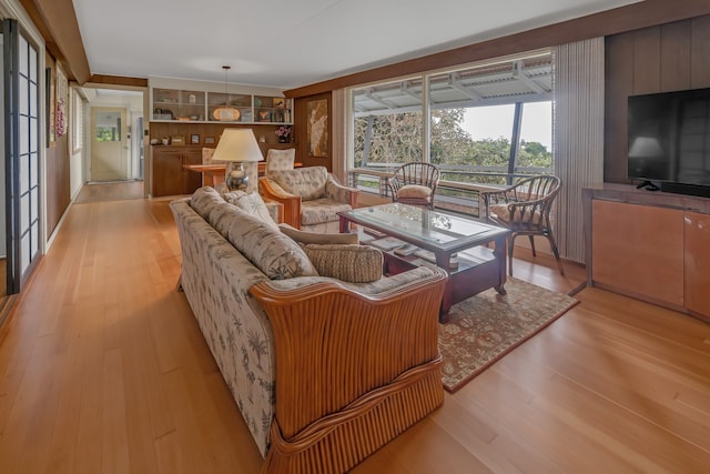 living area with light wood-type flooring and built in features