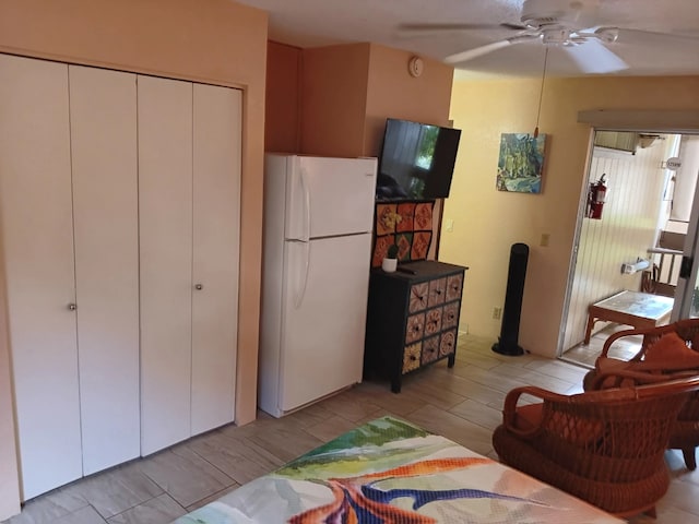 interior space with white refrigerator and ceiling fan