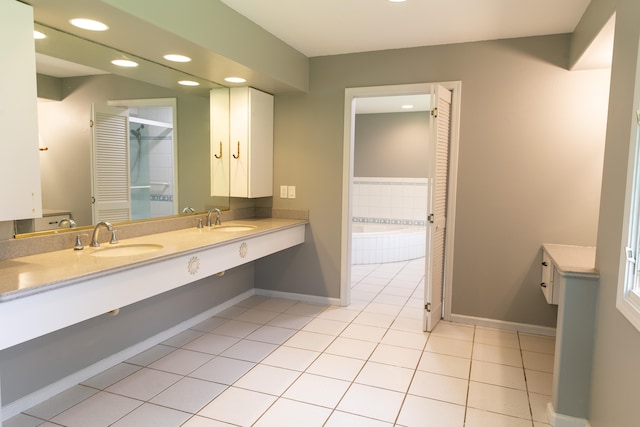 bathroom featuring vanity, tile patterned flooring, and a relaxing tiled tub