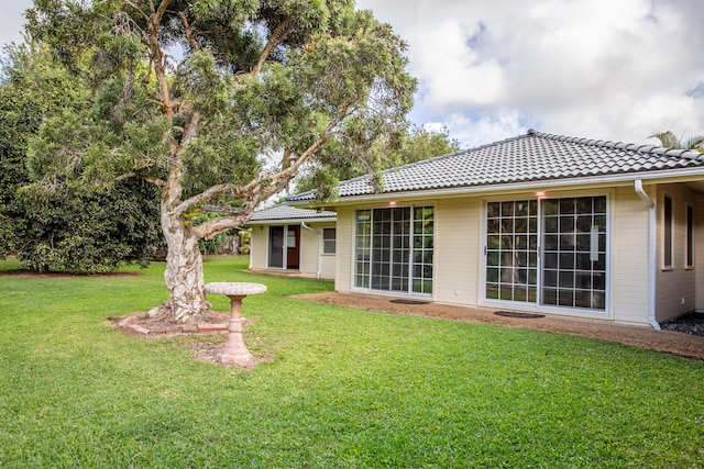 rear view of property featuring a yard