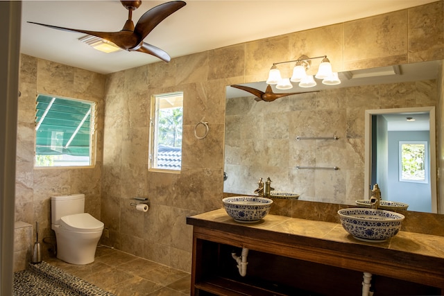 bathroom featuring ceiling fan, toilet, tile walls, and plenty of natural light