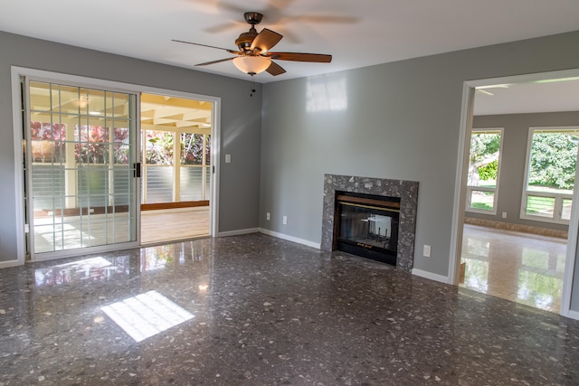 unfurnished living room with ceiling fan and a premium fireplace