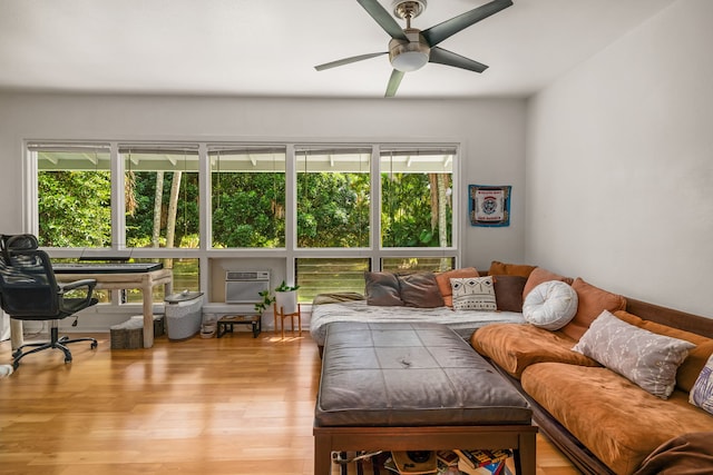 living area featuring light wood-type flooring, ceiling fan, and a wall mounted air conditioner