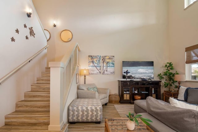 living room featuring light hardwood / wood-style floors and a high ceiling