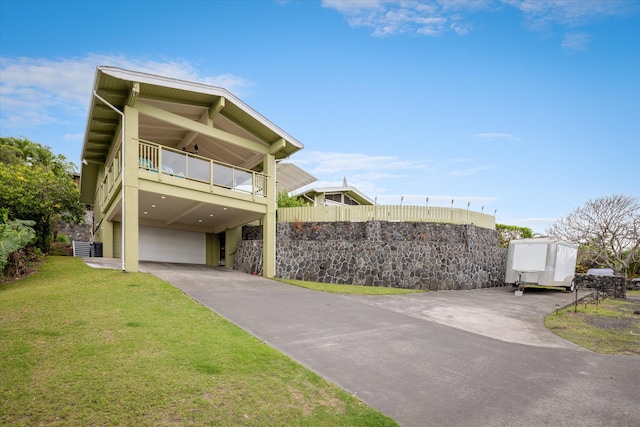 view of front of home featuring a carport, a balcony, a garage, driveway, and a front lawn