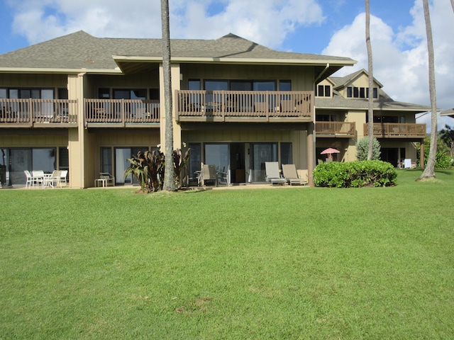 rear view of property featuring a lawn