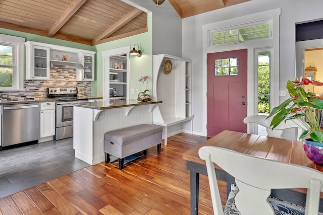 interior space with plenty of natural light, dark hardwood / wood-style floors, vaulted ceiling with beams, and wood ceiling