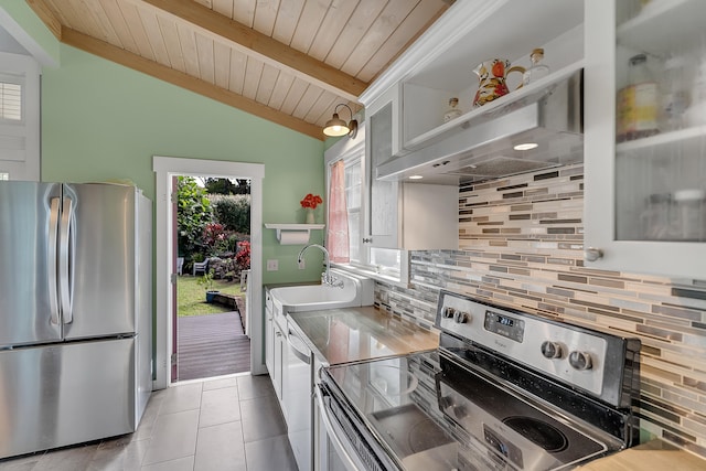 kitchen with tasteful backsplash, appliances with stainless steel finishes, light tile patterned floors, and white cabinets