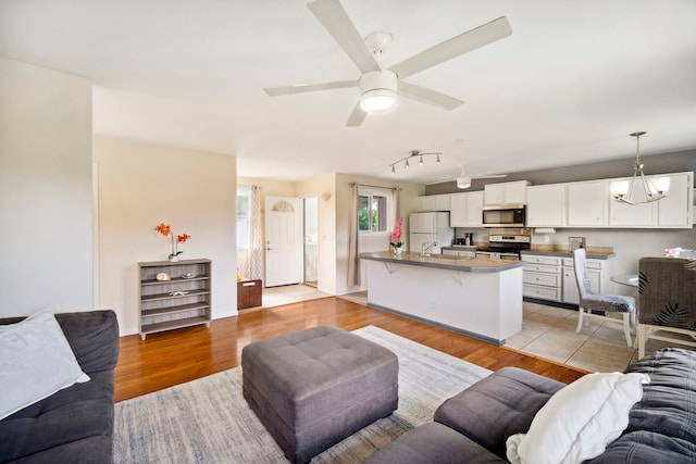 living area featuring light wood-style floors and a ceiling fan