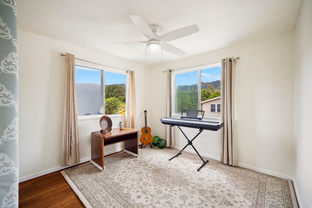 office space with baseboards, a ceiling fan, and wood finished floors