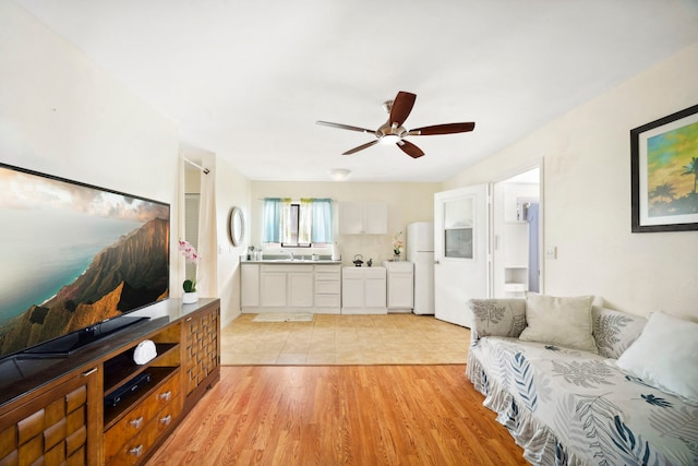 living room with a ceiling fan and light wood-style floors