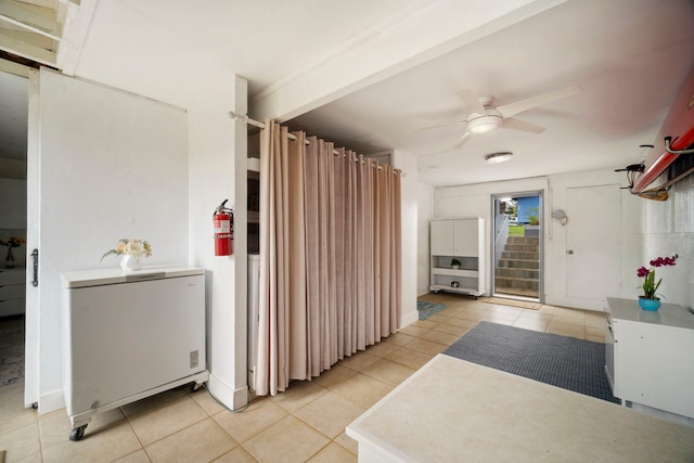 interior space with a ceiling fan and light tile patterned floors