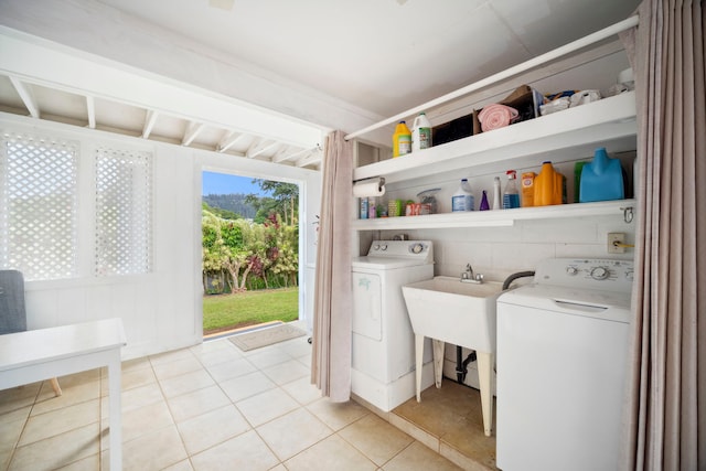 laundry room with laundry area, washer and clothes dryer, and light tile patterned flooring