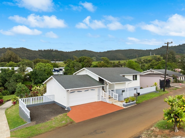 view of front of house featuring fence, a shingled roof, a garage, a mountain view, and concrete driveway