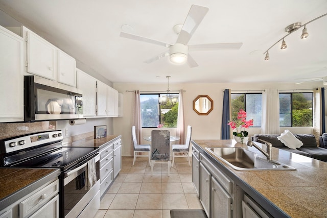kitchen featuring white cabinets, light tile patterned flooring, a sink, stainless steel appliances, and a ceiling fan