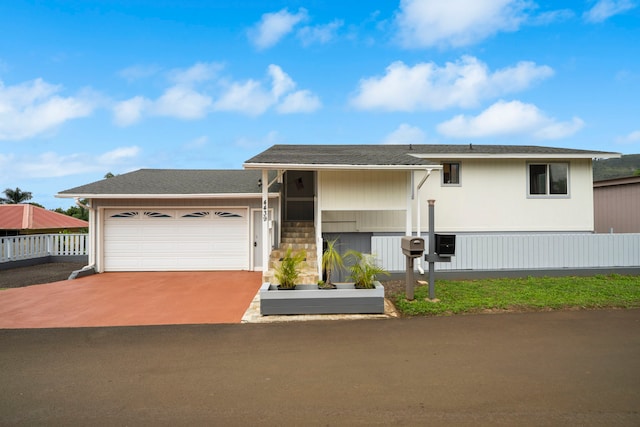 view of front of property featuring an attached garage, a shingled roof, fence, and driveway