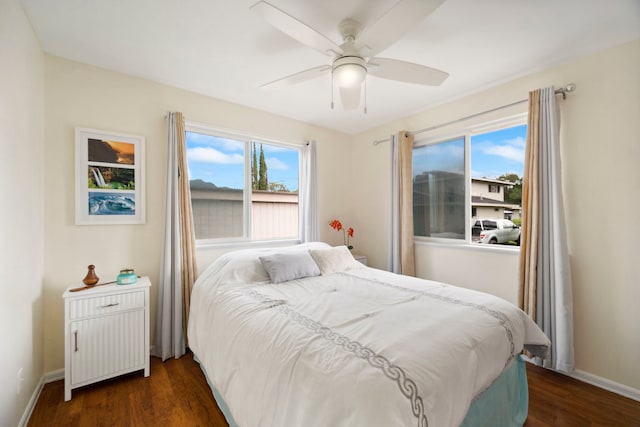 bedroom with dark wood-style flooring, baseboards, and a ceiling fan