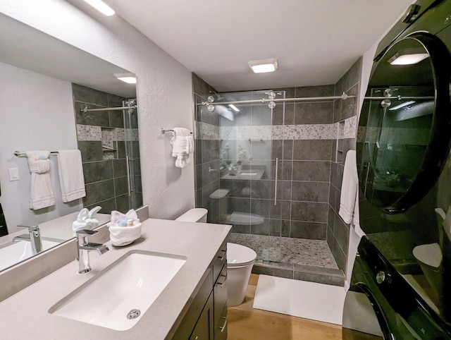 bathroom with hardwood / wood-style floors, toilet, an enclosed shower, and vanity