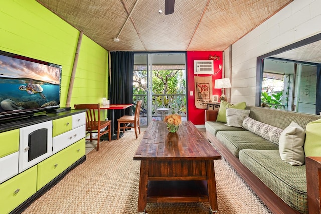 living area with a ceiling fan, a wealth of natural light, a wall mounted air conditioner, and carpet flooring