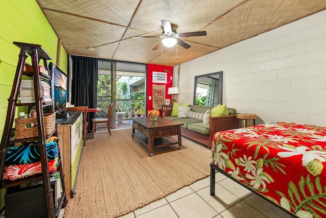 tiled living area with a ceiling fan and concrete block wall