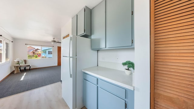 kitchen featuring white fridge, light wood-type flooring, and ceiling fan