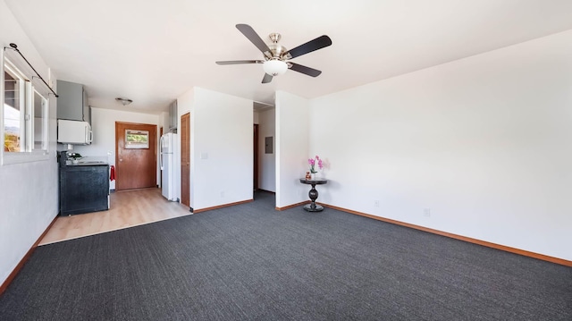 unfurnished room with electric panel, light colored carpet, and ceiling fan